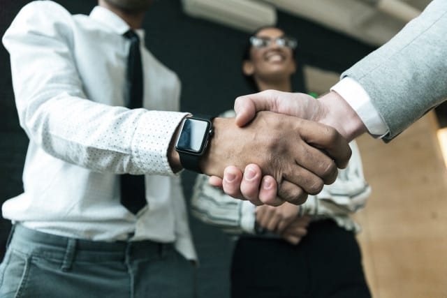 Witness the establishment of a powerful partnership as two business people shake hands in an office. Their collaboration is built on the principles of Equal Optics, where personalized support meets cutting-edge solutions, ensuring a mutually beneficial alliance.